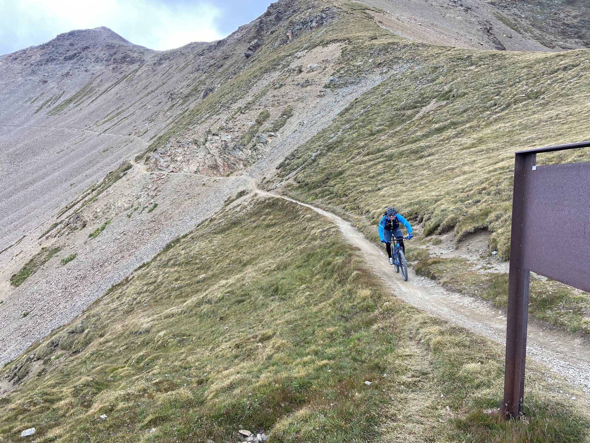 Mountain biker su un trail di cresta con vista sulla valle