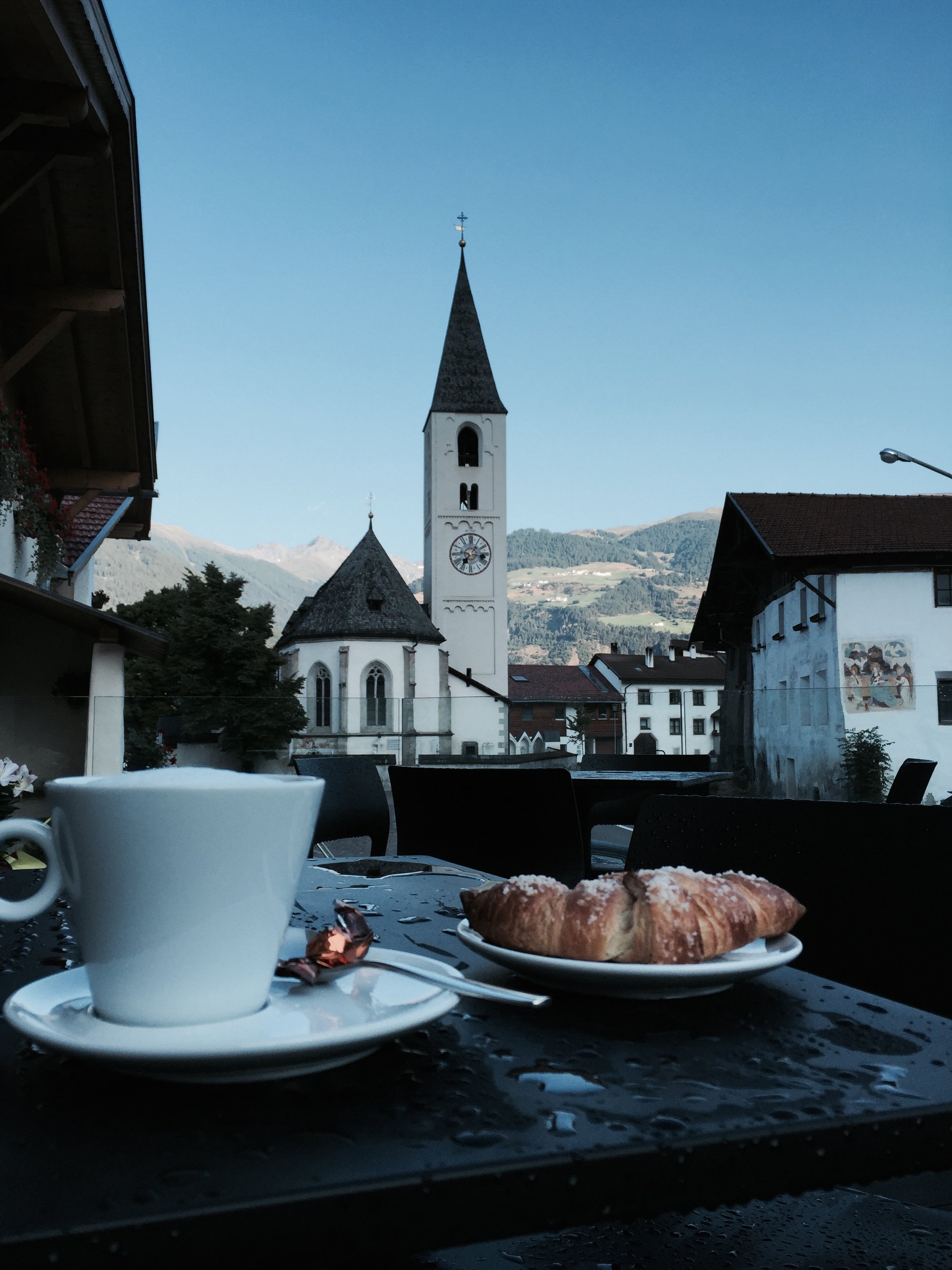 Cappuccino und Brioche auf der Terrasse mit Blick auf den Kirchturm