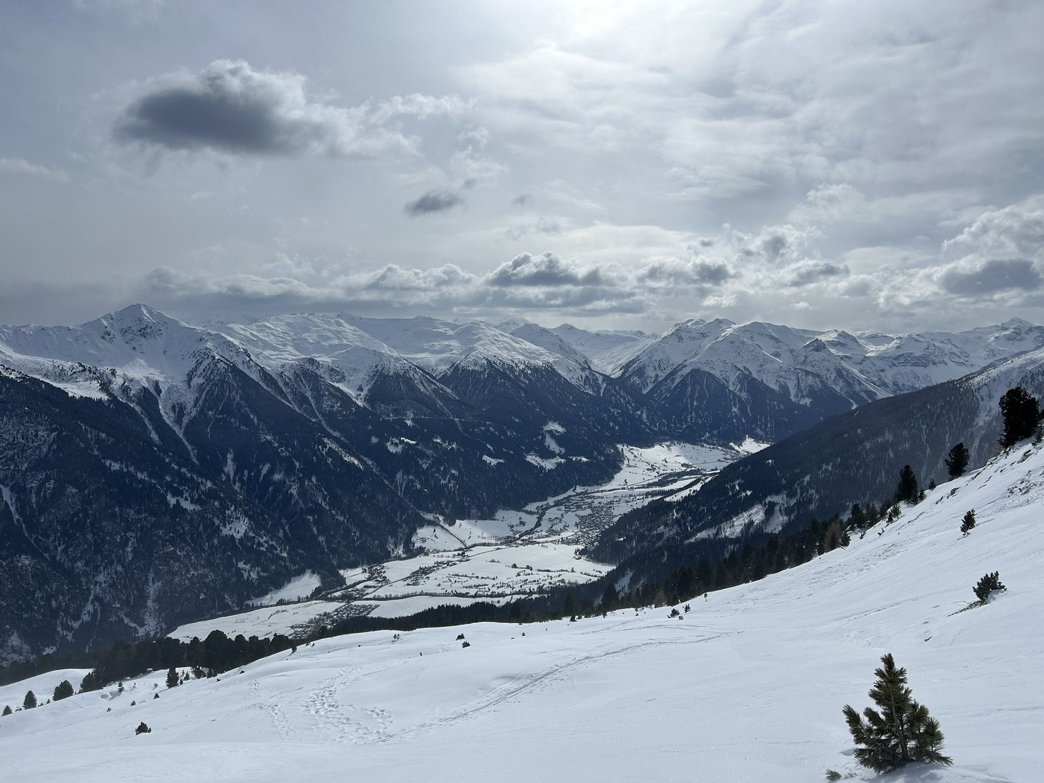 Snow-covered mountain valley under a cloudy sky